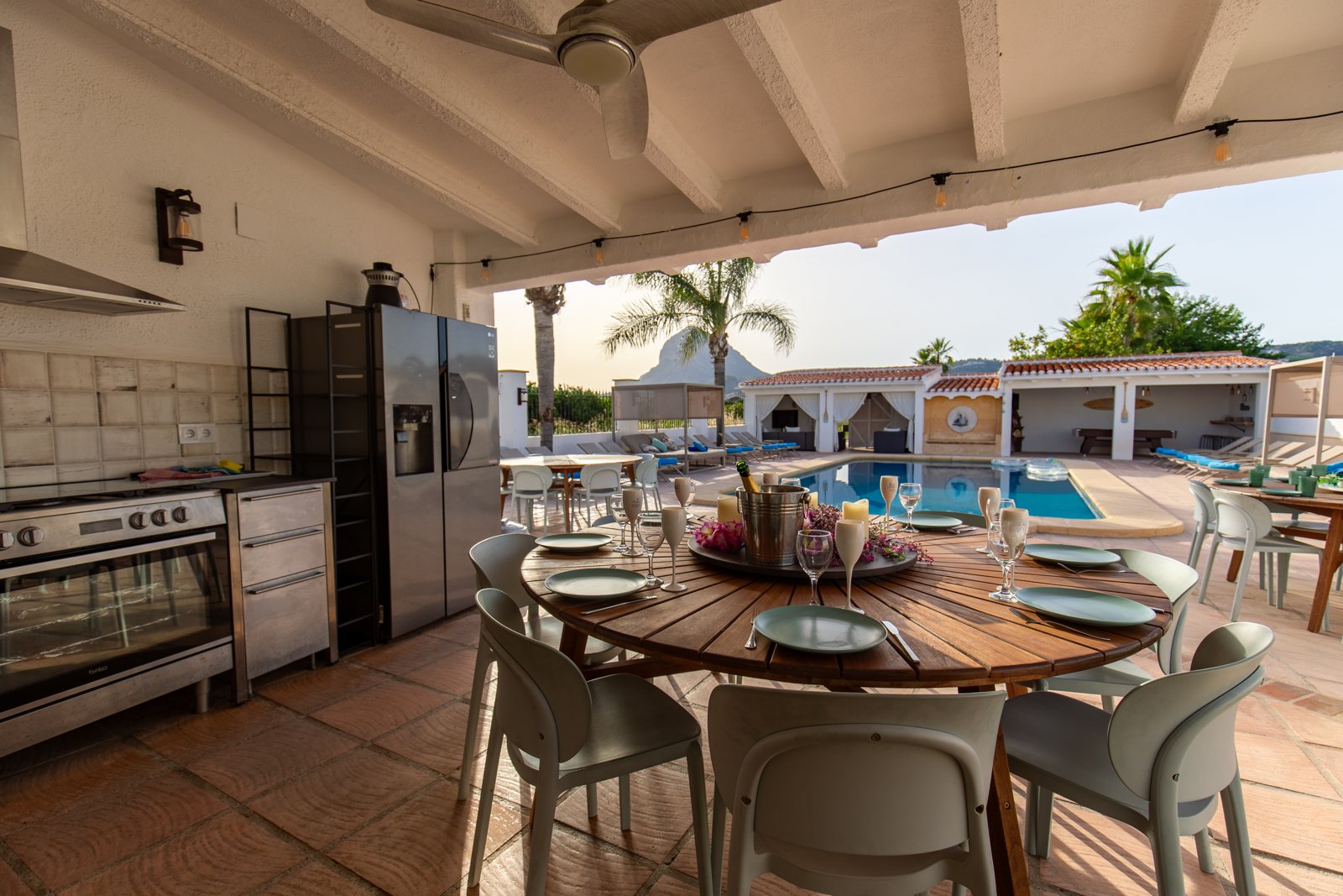 Outdoor kitchen with cooker, bar seating and dining table