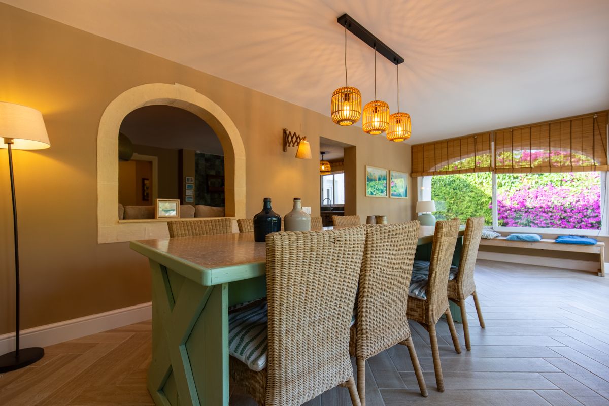 Rincón de comedor con sillas de mimbre junto al arco — Nauticaa, ala uno de Villa Palmview, Jávea