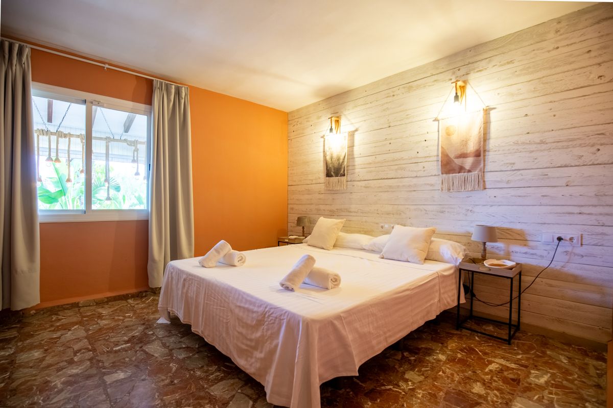 Dormitorio con pared de madera y color cálido — Mystique Travels, ala tres de Villa Palmview, Jávea