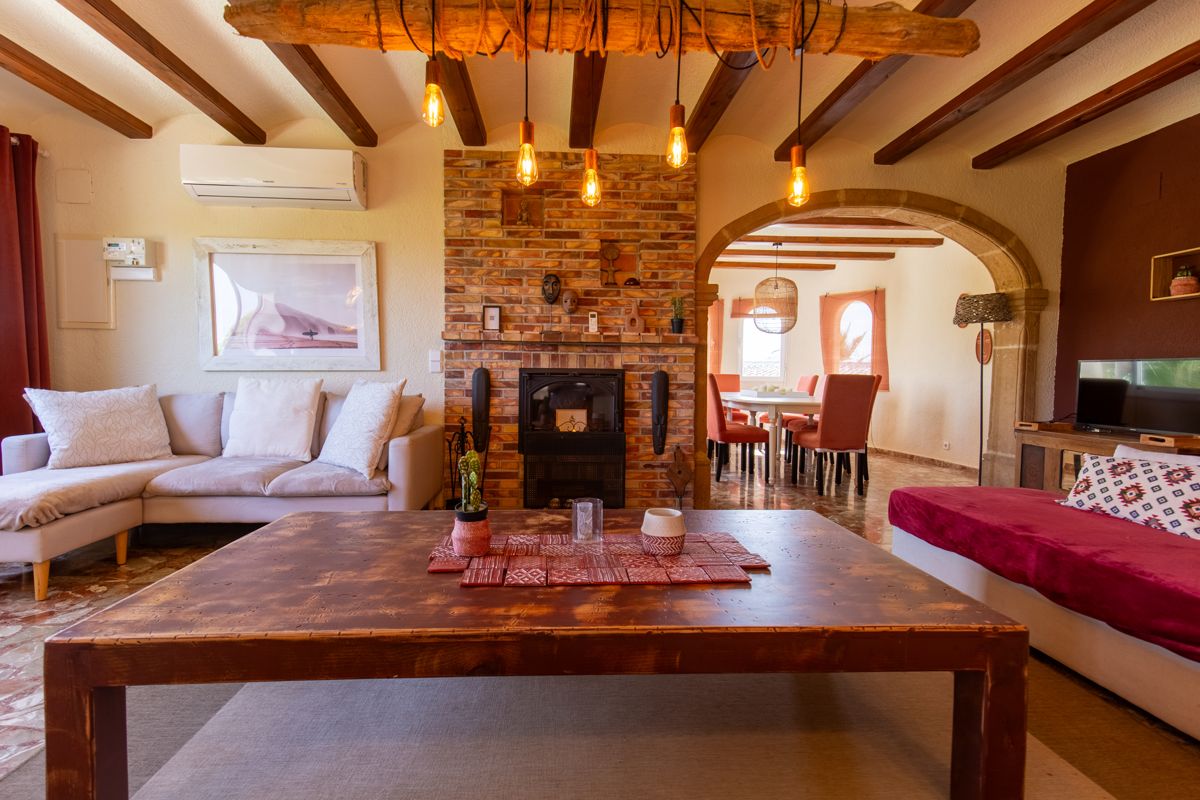 Living room with wooden table by the fireplace — Mystique Travels, wing three of Villa Palmview, Jávea