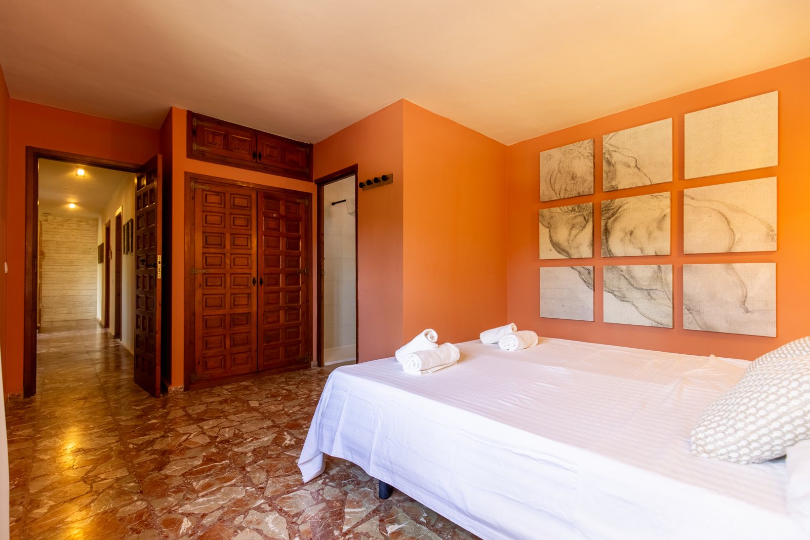 Dormitorio con pared de madera y color cálido — Mystique Travels, ala tres de Villa Palmview, Jávea