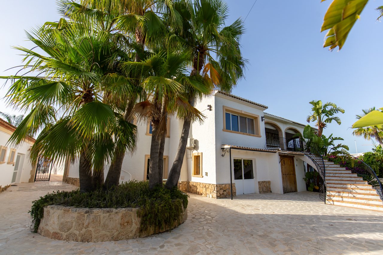Courtyard with fan palms and the white villa wing behind
