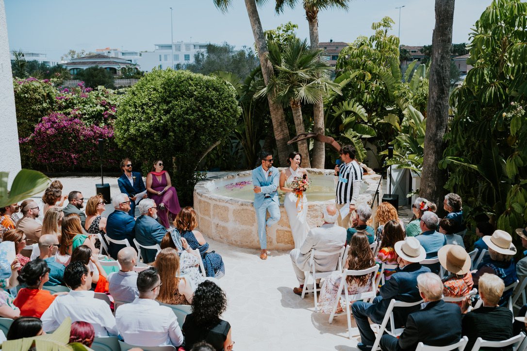 Cérémonie de mariage avec les invités assis dans les jardins de la villa