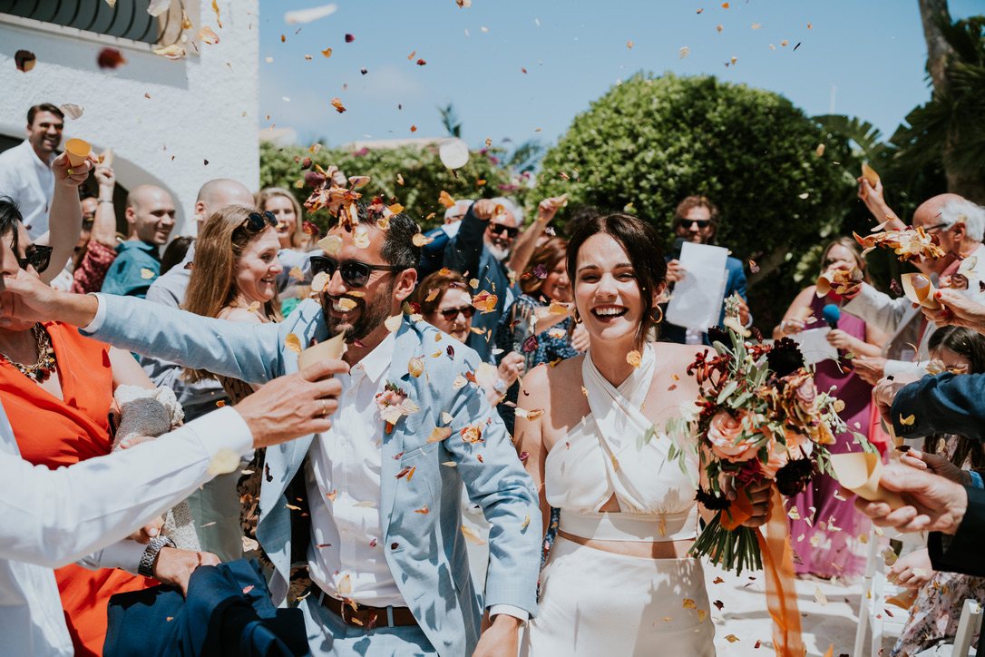 Les invités lancent des confettis sur les mariés à la villa
