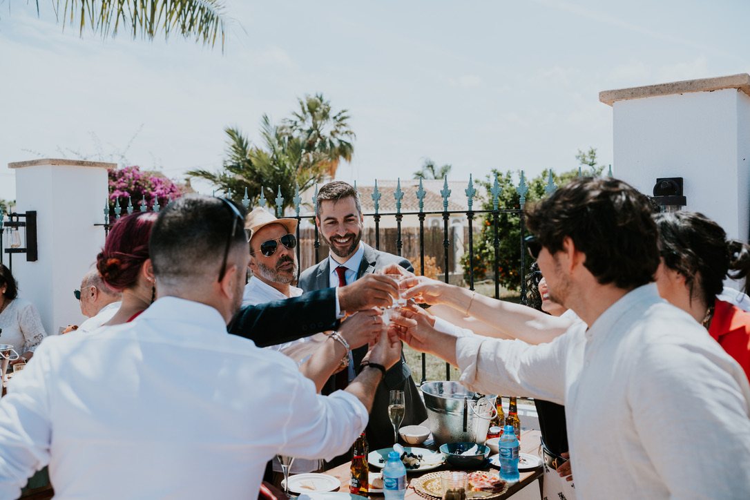 Les invités portent un toast à la table de mariage en extérieur
