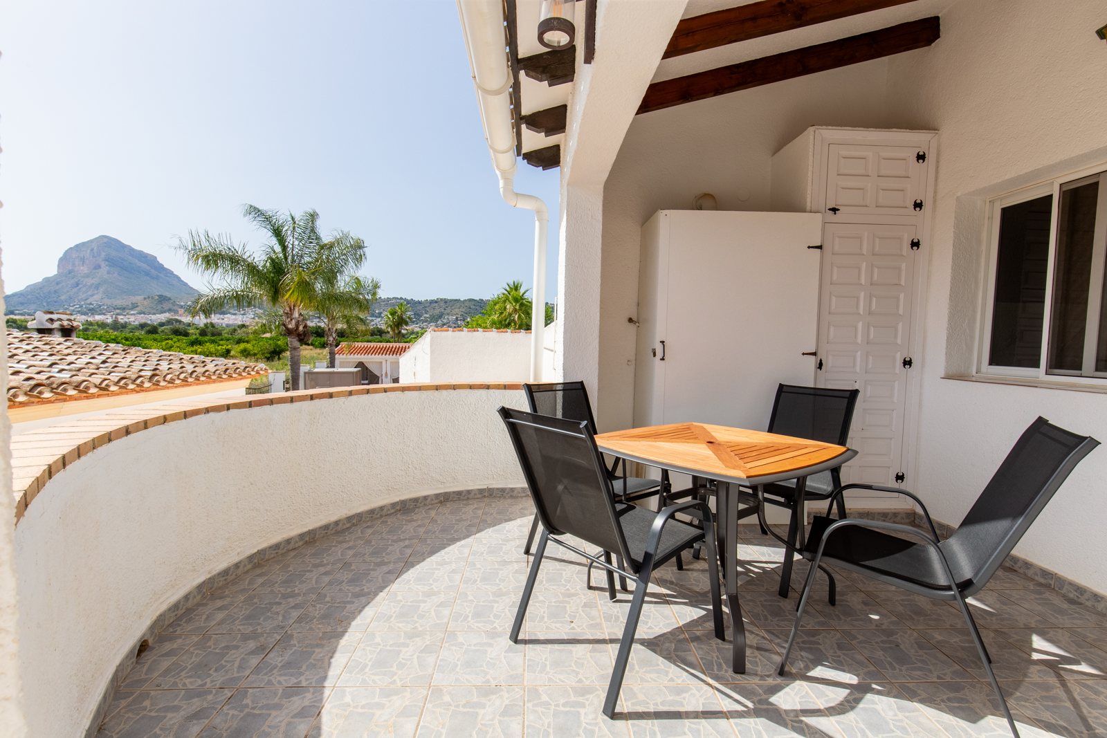 Terraza privada con mesa y sillas frente al Montgó
