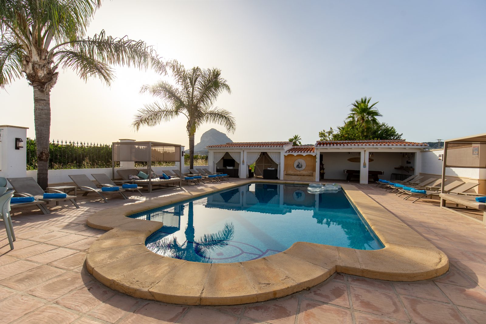 The saltwater pool in backlight with palms at sunset